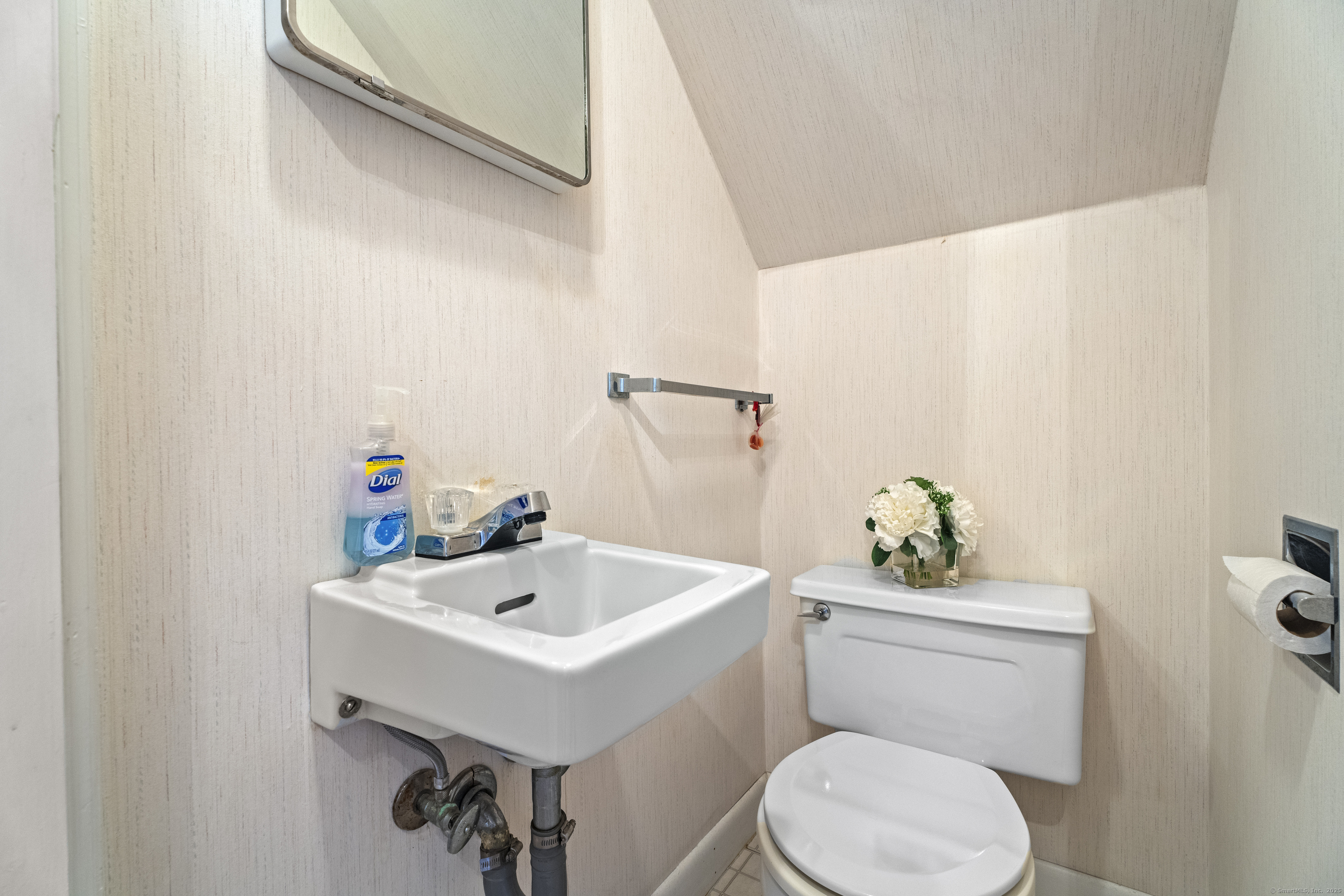 32 East Main Street Mystic, CT 06355 - Photo 12 of 40 a white toilet sitting next to a bathroom sink