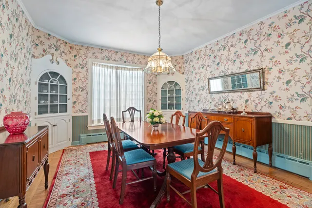 a dining room with furniture a chandelier and wooden floor