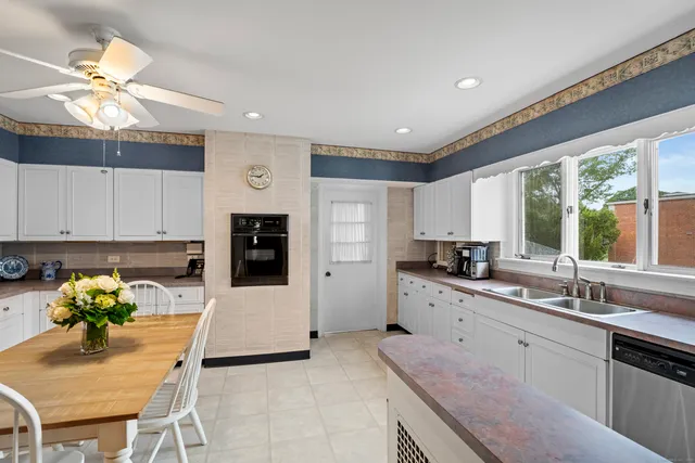 a kitchen with granite countertop a sink stainless steel appliances and window