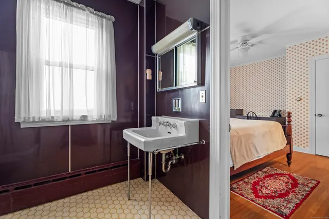 a bedroom with a bed and a dresser next to a window