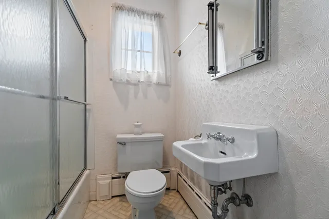 a bathroom with a sink toilet and mirror