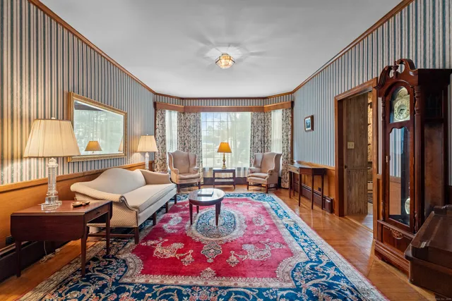 a living room with furniture a rug and a large window