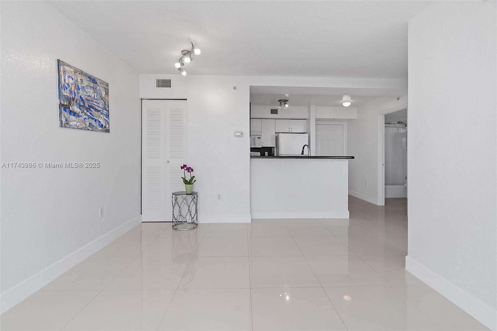 219 Northwest 12th Avenue, Unit 809 Miami, FL 33128 - Photo 12 of 32 a view of a living room hardwood floor and a ceiling fan