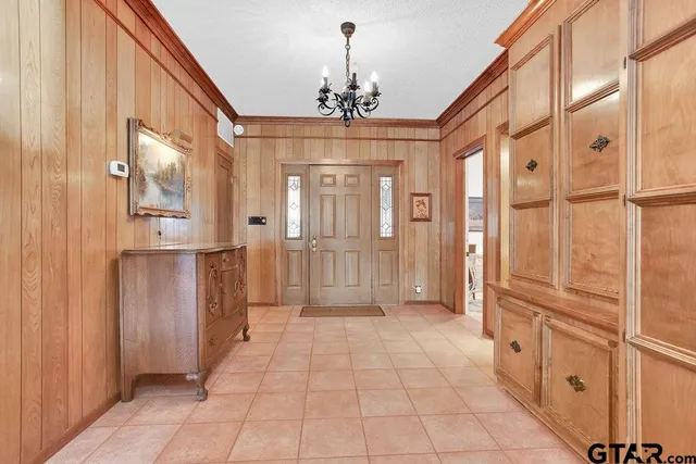 a view of a hallway with chandelier and entryway
