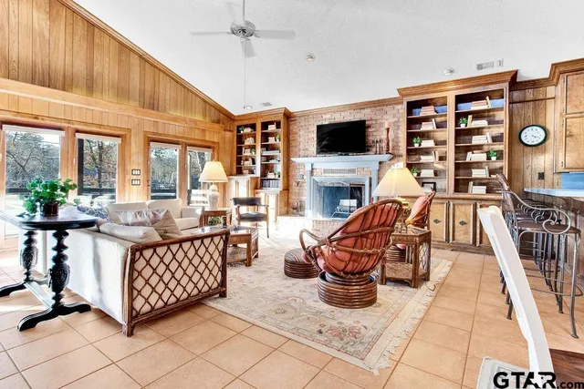 a living room with furniture a flat screen tv and a floor to ceiling window
