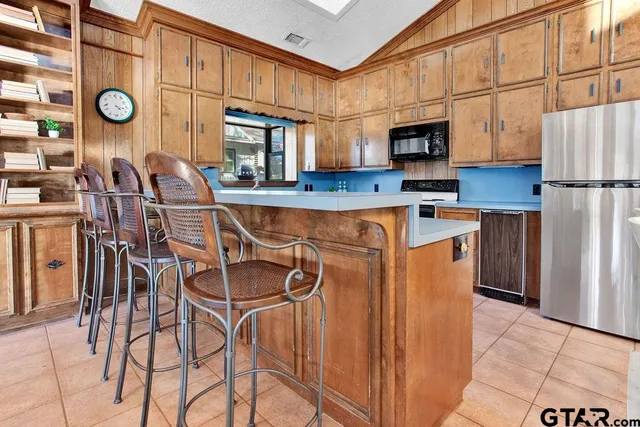 a kitchen with stainless steel appliances a refrigerator and microwave