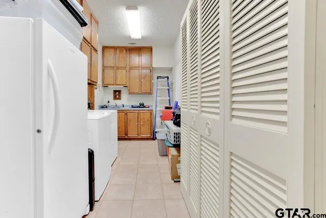 a kitchen with a refrigerator and white cabinets