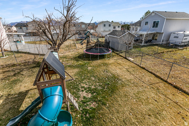 4239 West 5325th Street South Roy, UT 84067 - Photo 21 of 26 Fenced backyard with a trampoline and a residential view