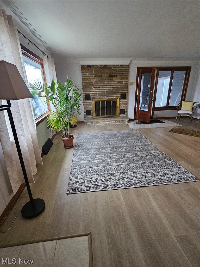 3700 Jaeger Road Lorain, OH 44053 - Photo 13 of 50 Unfurnished living room featuring light hardwood / wood-style flooring, a textured ceiling, crown molding, and a fireplace
