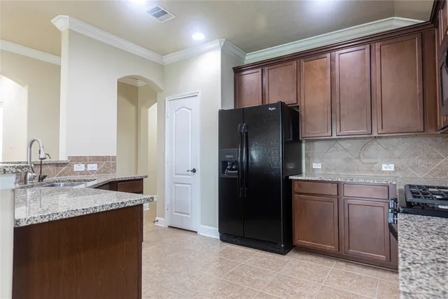 a kitchen with stainless steel appliances granite countertop a refrigerator and a sink