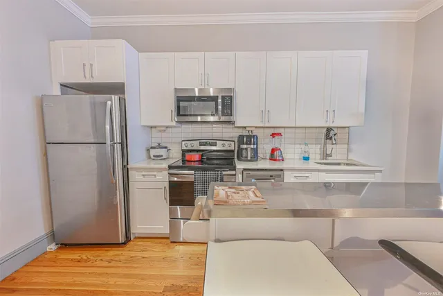 a kitchen with stainless steel appliances granite countertop a refrigerator sink and stove