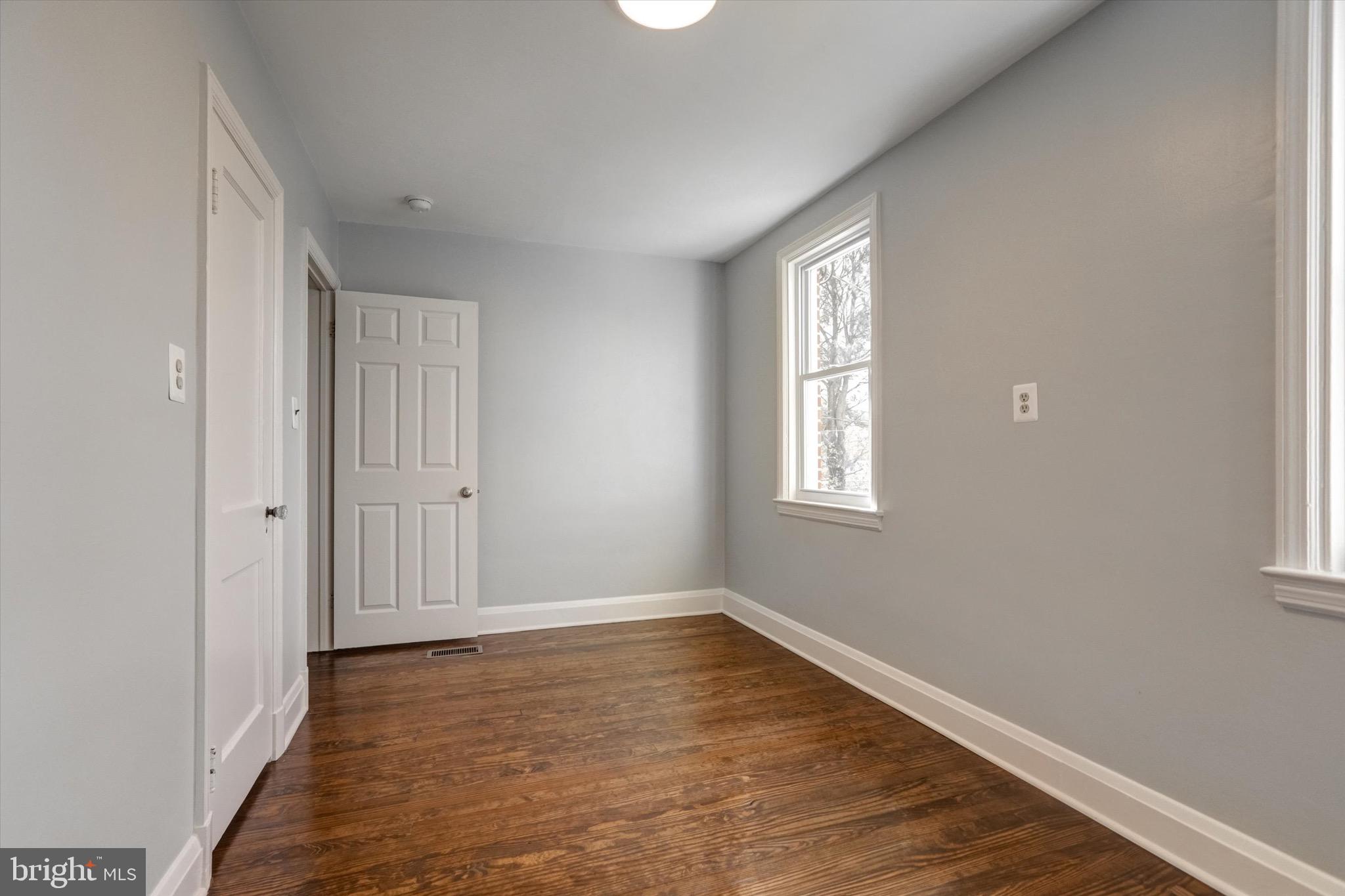 3111 Willoughby Road Baltimore, MD 21234 - Photo 23 of 45 a view of an empty room with wooden floor and a window