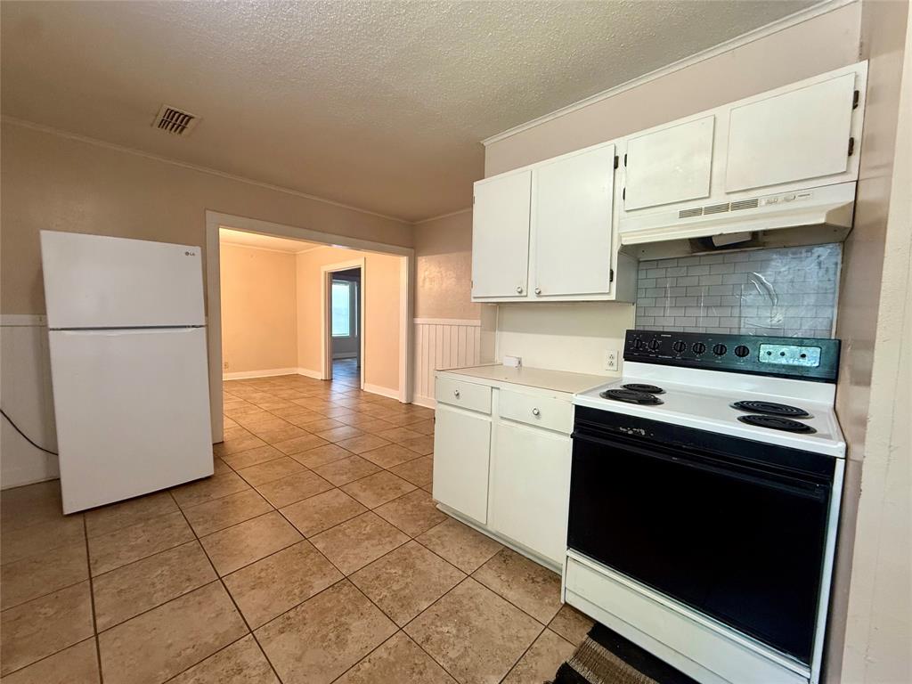 217 3rd St Pinehill Springhill, LA 71075 - Photo 5 of 23 Kitchen featuring tile flooring, white cabinetry, and a white refrigerator