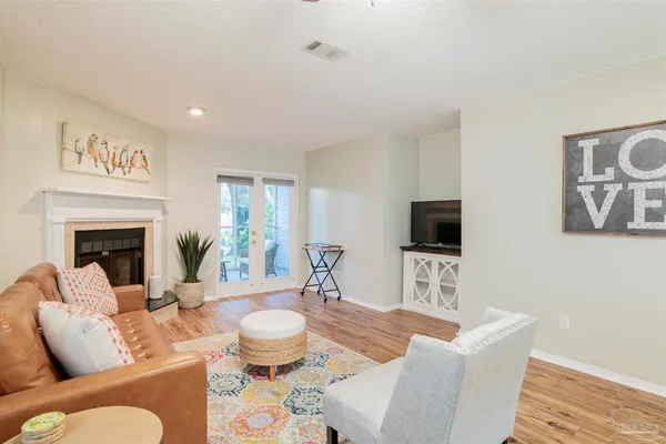 a living room with furniture a fireplace and a flat screen tv