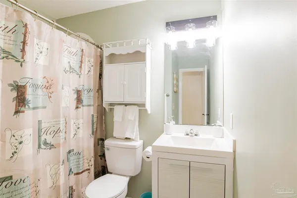 a bathroom with a sink a toilet and shower curtain
