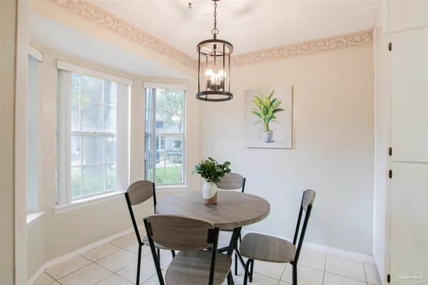 a dining room with furniture a chandelier and window