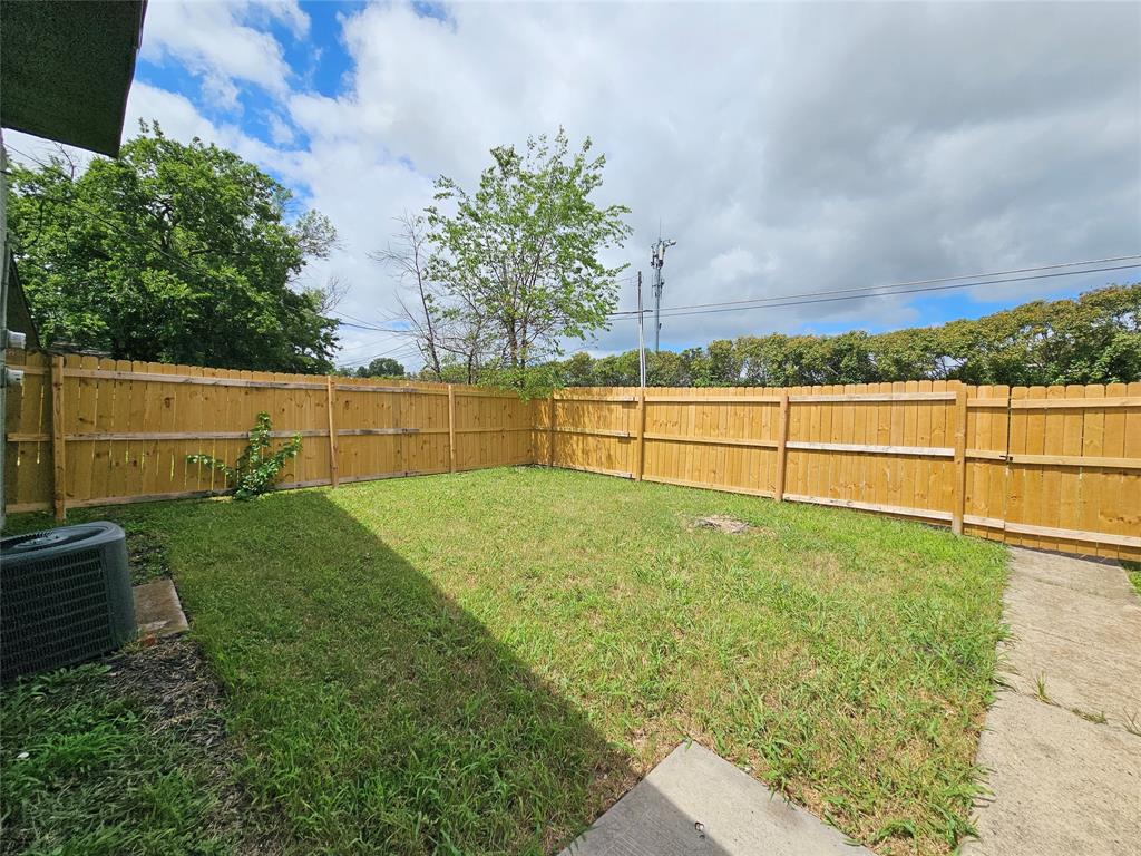 1725 R Avenue, Unit 1727 Plano, TX 75074 - Photo 18 of 20 Expansive backyard featuring a manicured lawn, complete wood fencing, and a concrete patio area
