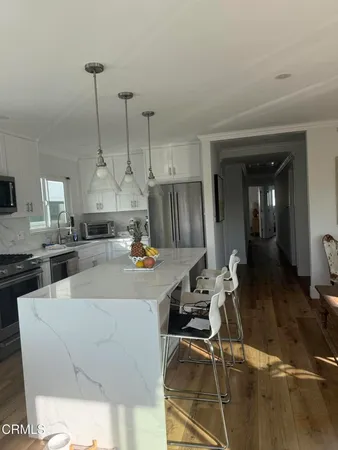 a large kitchen with a table chairs stove and cabinets