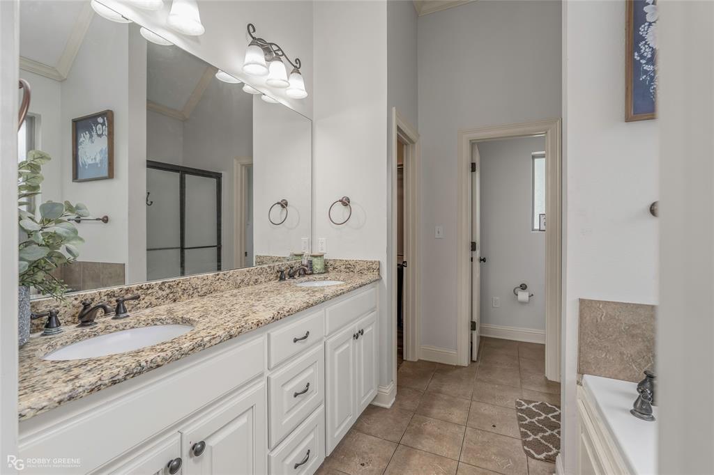 711 Reeds Reef Bossier City, LA 71112 - Photo 18 of 36 a bathroom with a granite countertop sink a mirror and a shower