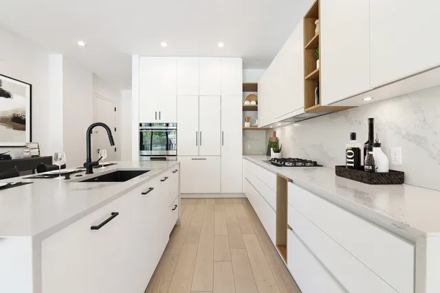 a kitchen with stainless steel appliances granite countertop a sink stove and cabinets