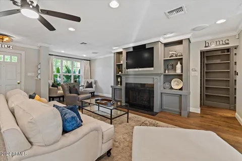 a living room with kitchen island dining table wooden floor and a kitchen view
