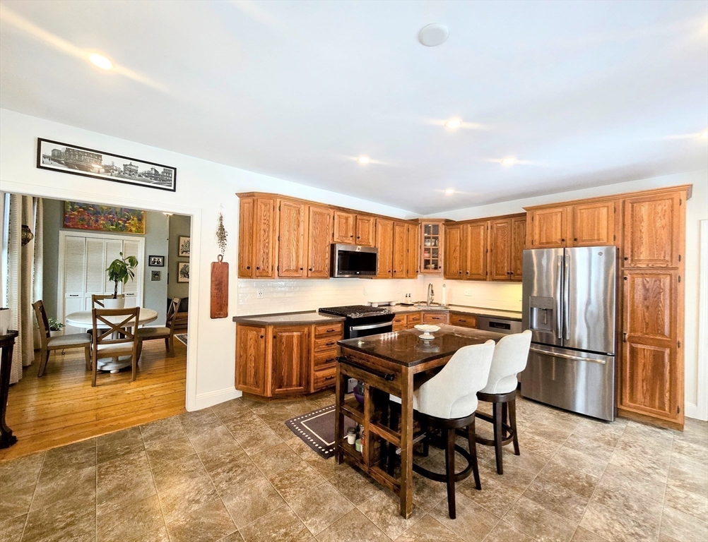 199 Rhode Island Road Lakeville, MA 02347 - Photo 7 of 30 a kitchen with stainless steel appliances granite countertop a stove top oven a sink dishwasher and a refrigerator with wooden cabinets