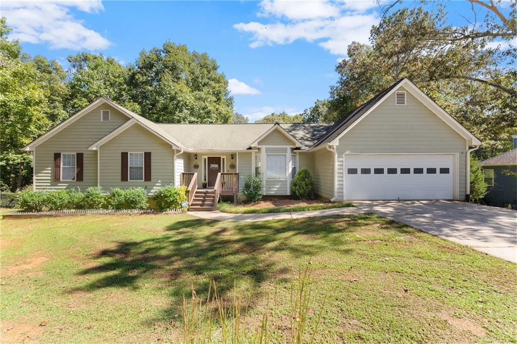 6745 Payton Road Cumming, GA 30041 - Photo 1 of 1 a front view of a house with a garden and tree