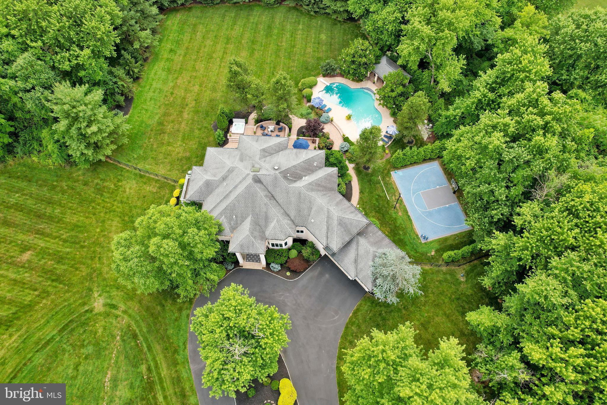 an aerial view of a house with a yard basket ball court and outdoor seating