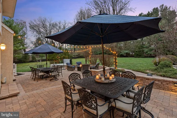 a view of a house with a yard plants and a large tree