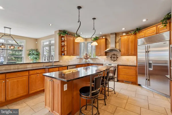 a kitchen with stainless steel appliances granite countertop a sink a oven and a refrigerator