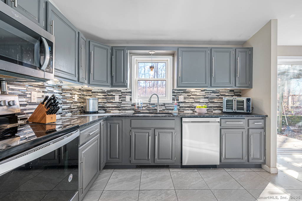 437 Somers Road Ellington, CT 06029 - Photo 11 of 40 a kitchen with stainless steel appliances granite countertop a stove sink and cabinets