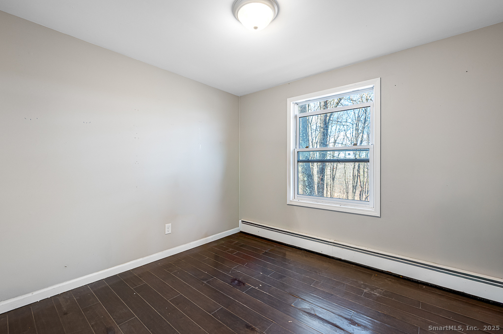 437 Somers Road Ellington, CT 06029 - Photo 20 of 40 an empty room with wooden floor and windows