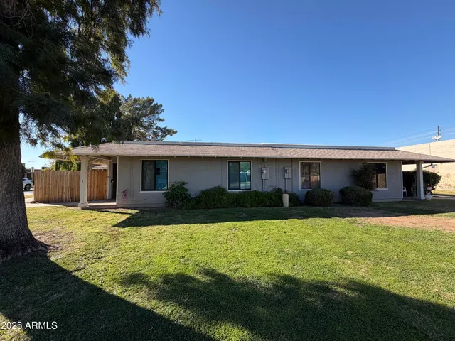 a view of a house with a yard and sitting area