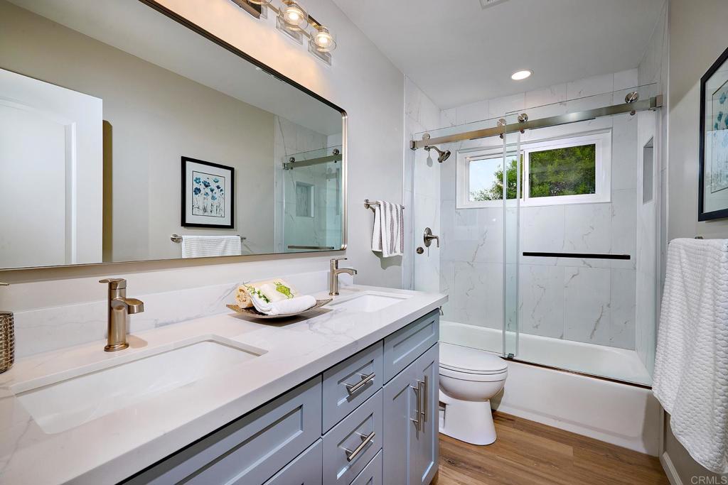 341 Cole Ranch Road Encinitas, CA 92024 - Photo 28 of 44 a bathroom with a granite countertop sink a toilet a mirror and shower