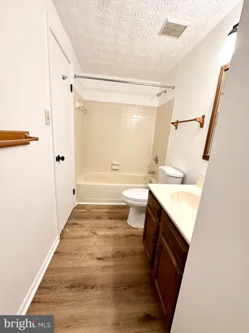 a bathroom with a sink a toilet a tub and shower