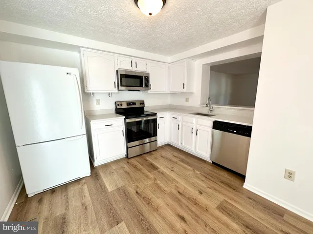 a kitchen with white cabinets and white appliances
