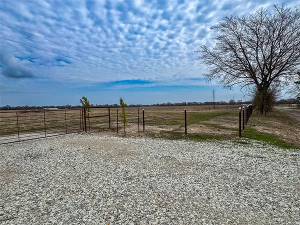 a view of a yard with wooden fence