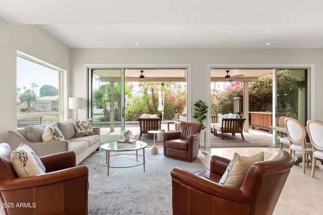 a kitchen with stainless steel appliances granite countertop a sink a stove a refrigerator cabinets and chairs