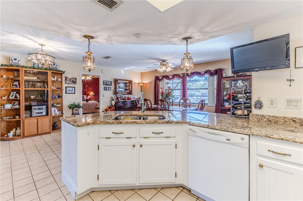 11249 Riddle Drive Spring Hill, FL 34609 - Photo 17 of 43 a kitchen with stainless steel appliances granite countertop a sink and cabinets