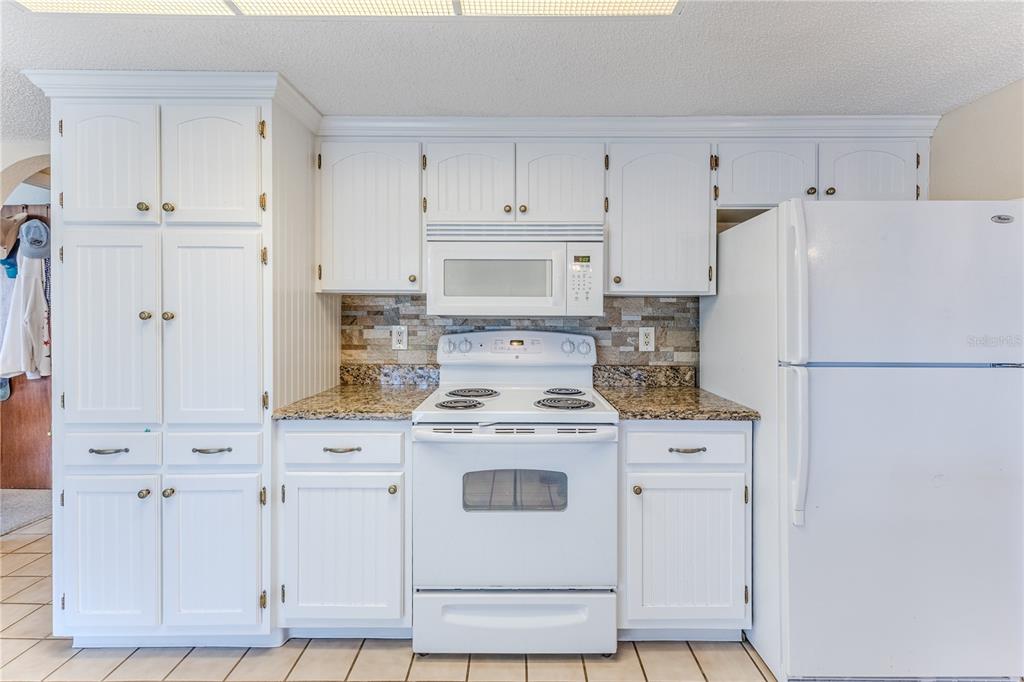 11249 Riddle Drive Spring Hill, FL 34609 - Photo 18 of 43 a white refrigerator freezer sitting inside of a kitchen