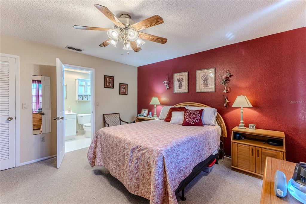 11249 Riddle Drive Spring Hill, FL 34609 - Photo 21 of 43 a bedroom with a bed and a chandelier