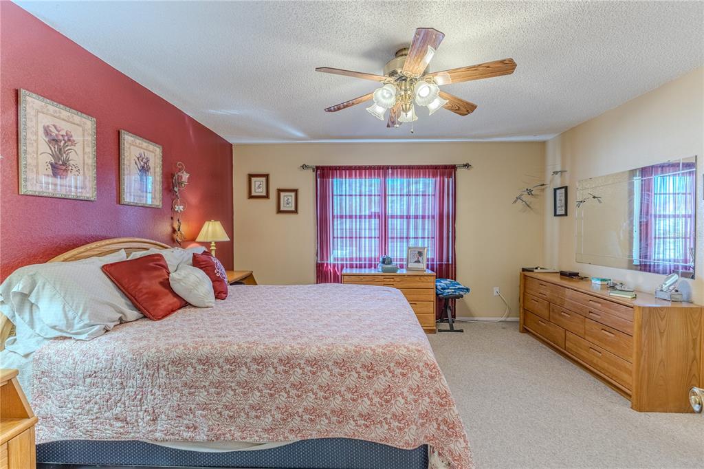 11249 Riddle Drive Spring Hill, FL 34609 - Photo 23 of 43 a bedroom with a large bed and a chandelier