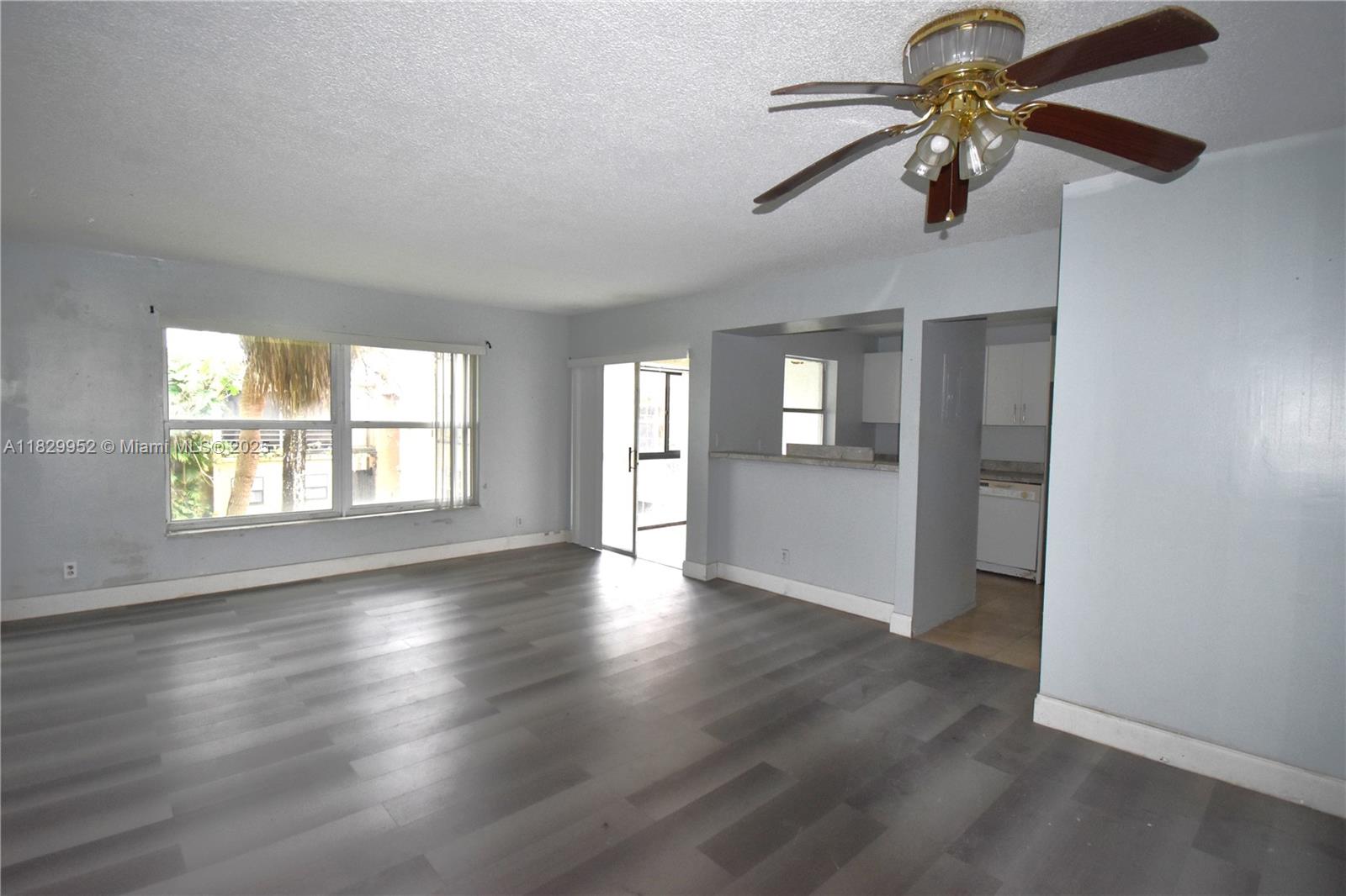 4231 Northwest 19th Street, Unit 256 Lauderhill, FL 33313 - Photo 5 of 16 an empty room with wooden floor chandelier fan and windows