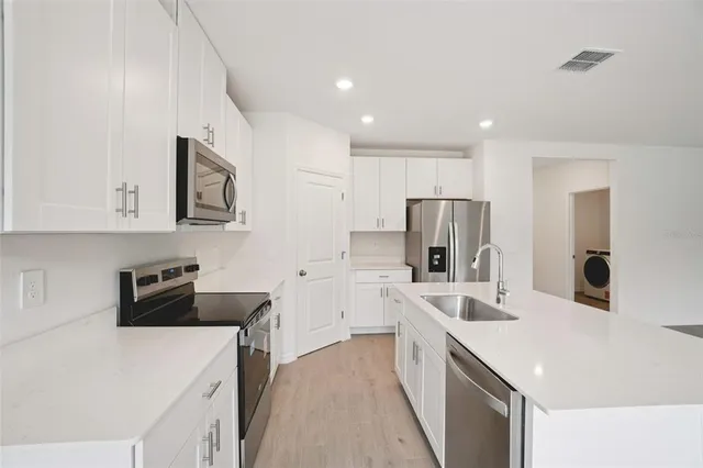 a kitchen that has a sink a stove and refrigerator