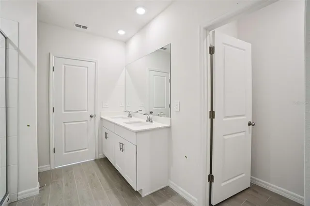 a bathroom with a double vanity sink and mirror