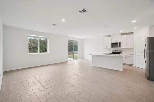 a view of kitchen with stainless steel appliances granite countertop a stove a sink and a refrigerator