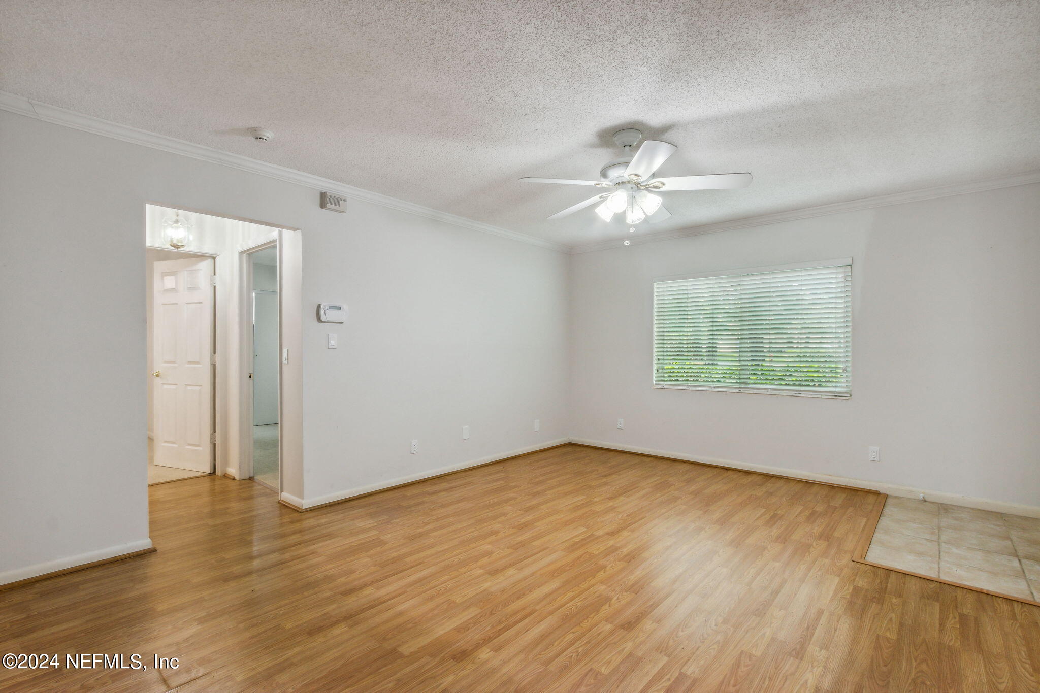 1213 The Grove Road Orange Park, FL 32073 - Photo 11 of 40 an empty room with wooden floor chandelier fan and windows