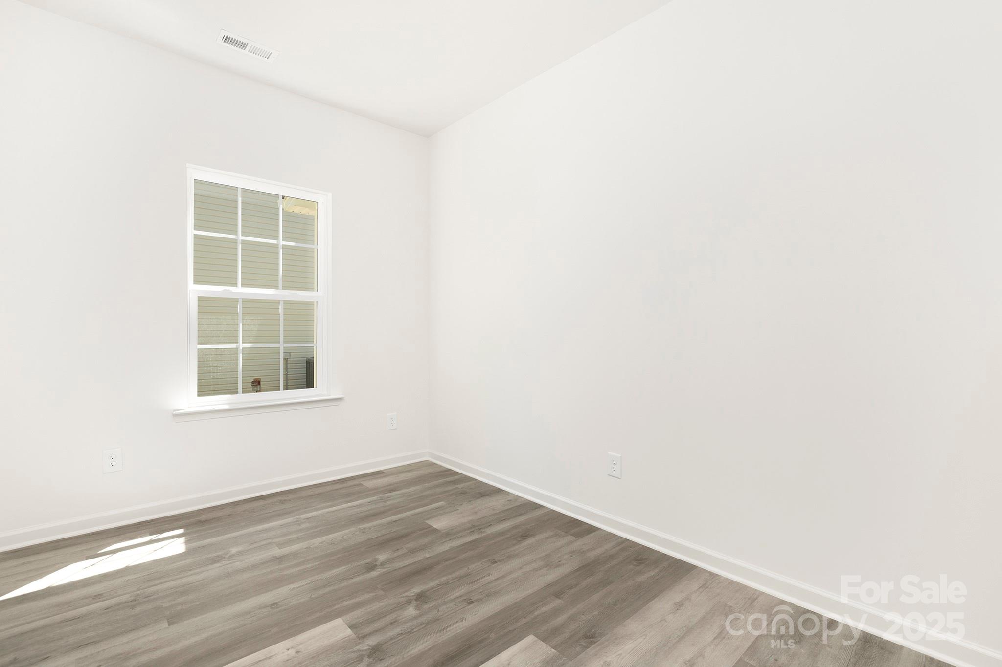 7601 Boswell Road Charlotte, NC 28215 - Photo 14 of 22 an empty room with wooden floor and windows