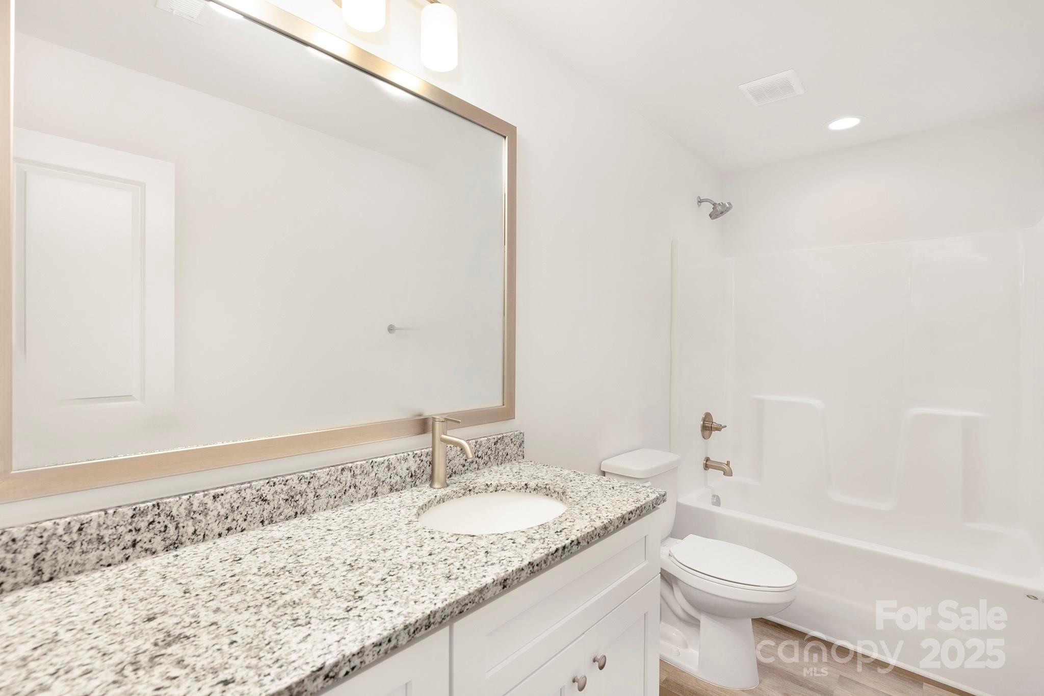 7601 Boswell Road Charlotte, NC 28215 - Photo 16 of 22 a bathroom with a granite countertop sink and a mirror