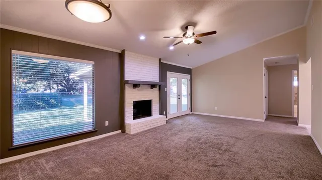 a view of an empty room with a fireplace and a window